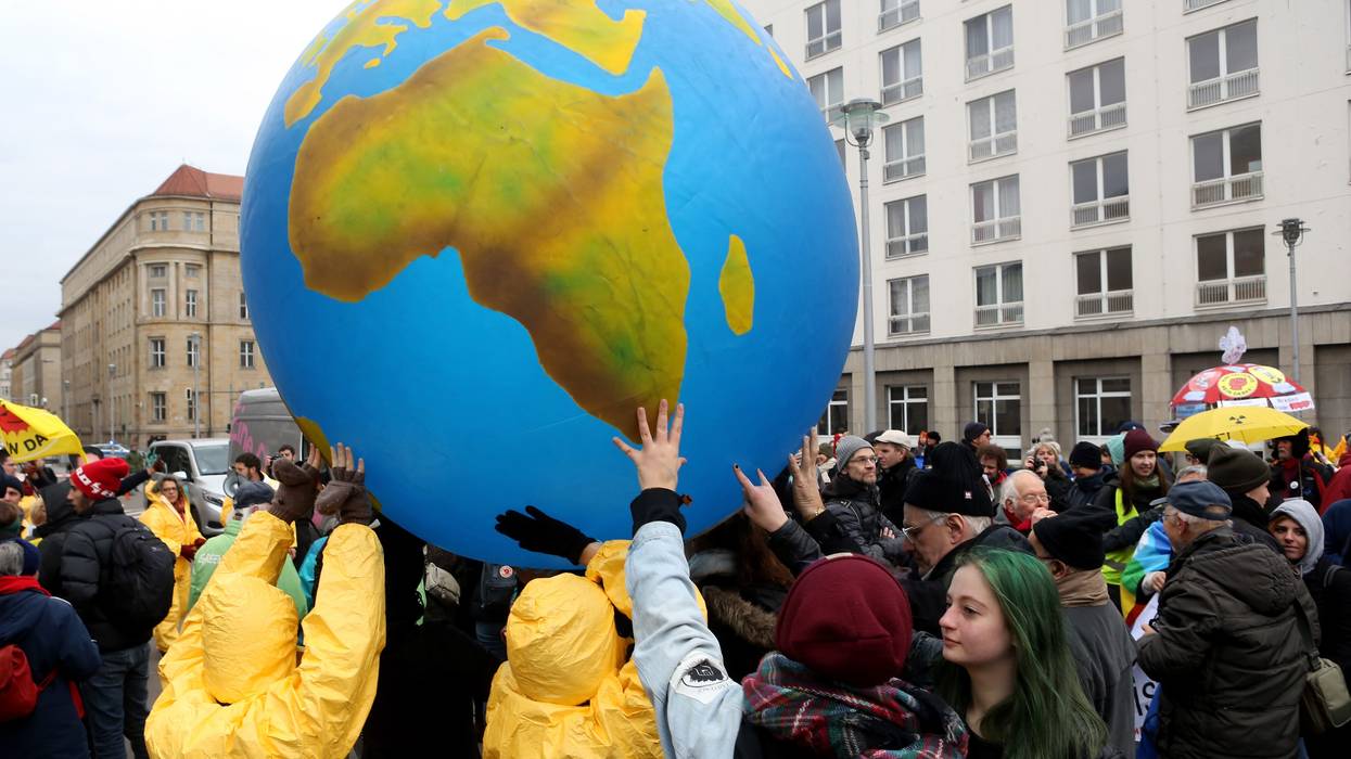 Activists hold up a large globe.