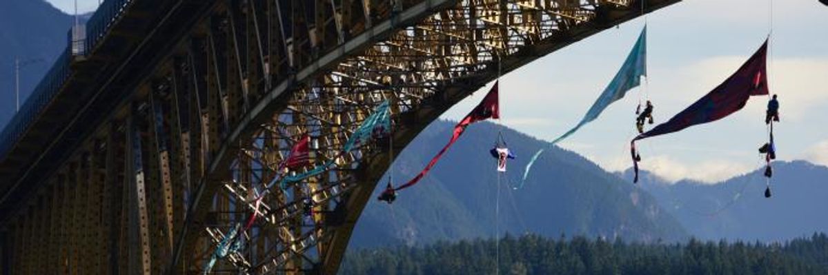 Activists launched an aerial bridge blockade in the path of a Trans Mountain tar sands oil tanker at the Ironworkers Memorial Bridge in Vancouver, British Columbia on July 3, 2018