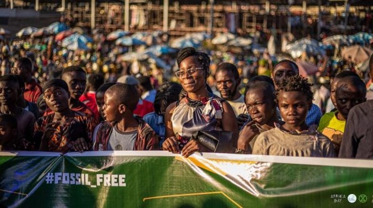 Activists march behind a banner reading, "Fossil Free."