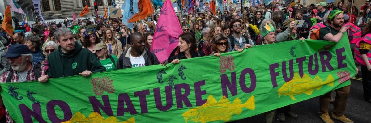 Activists march with banners & placards past Westminster Abbey on the biodiversity protest at Parliament Square on April 21, 2023 in London, England.