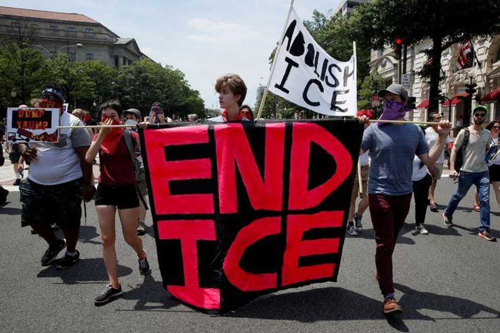 Activists protest the Trump administration's immigration policies outside the Department of Justice in Washington, June