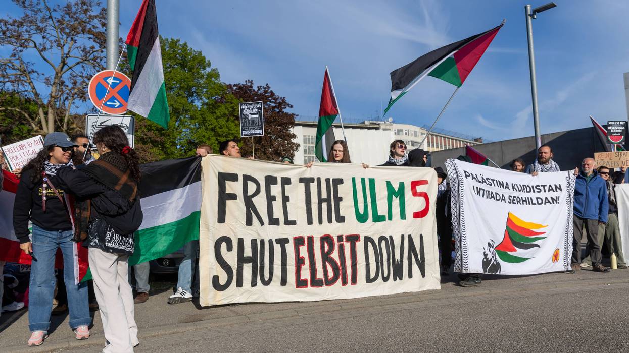 Activists unfurl a banner in solidarity with jailed pro-Palestine activists in Germany.