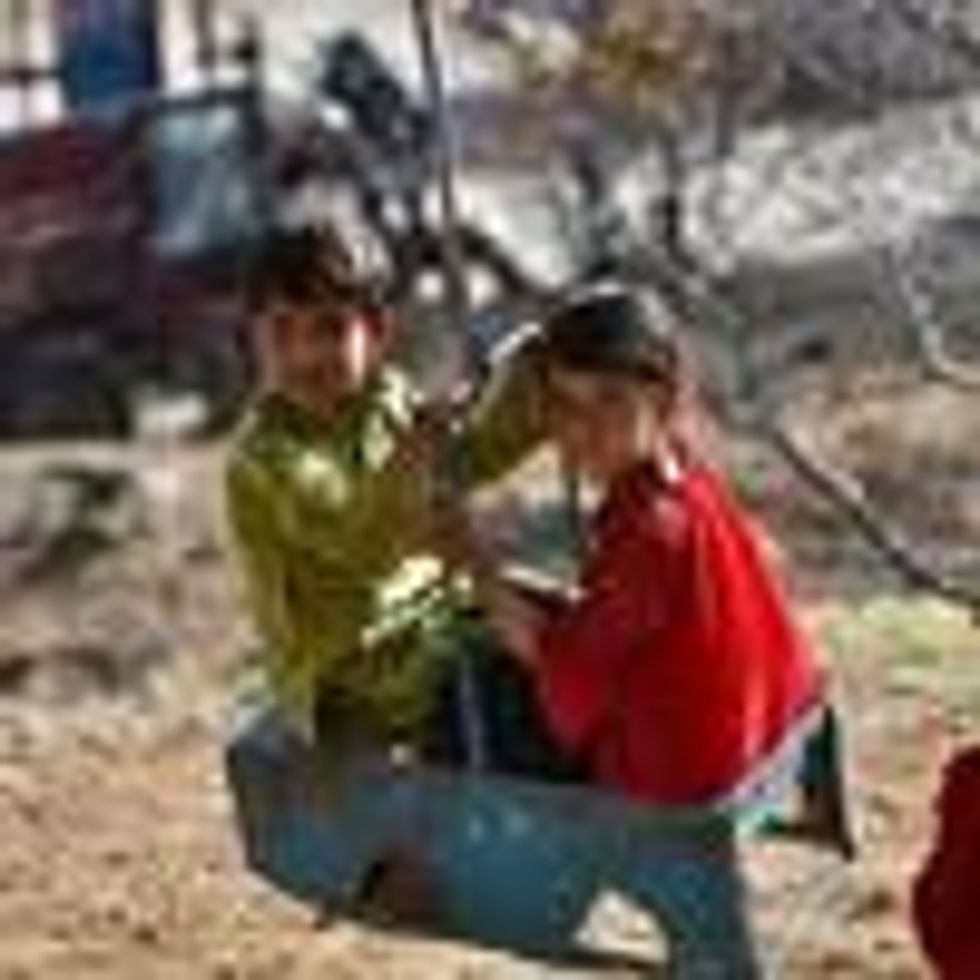 Afghan children ride on a swing