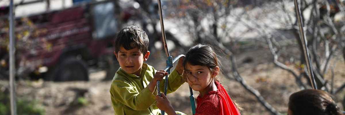 Afghan children ride on a swing