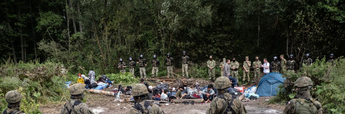 Afghan refugees are surrounded by security forces at the Poland-Belarus border on August 26, 2021. The group of migrants from Afghanistan has been stuck at the E.U.'s eastern border for several weeks as Belarus and Poland both refuse to let them in. (Photo: Maciej Moskwa/NurPhoto via Getty Images)