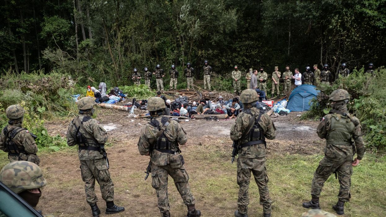 Afghan refugees are surrounded by security forces at the Poland-Belarus border on August 26, 2021. The group of migrants from Afghanistan has been stuck at the E.U.'s eastern border for several weeks as Belarus and Poland both refuse to let them in. (Photo: Maciej Moskwa/NurPhoto via Getty Images)