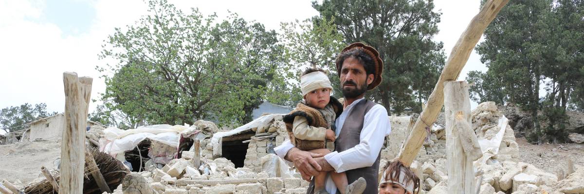Afghans who lost family membrers in a recent earthquake examine the ruins