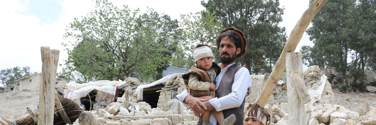 Afghans who lost family membrers in a recent earthquake examine the ruins