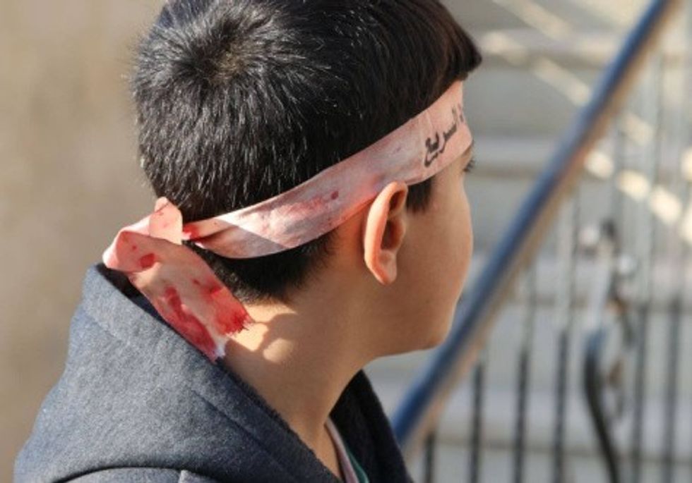 Ahmed al-Kholi wears the bloodied headband of his cousin Yousef, 22, killed by Israeli forces in Tulkarem