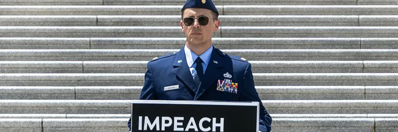 air-force-maj-jason-watson-stands-on-the-steps-of-the-us-capitol-in-washington-dc-holding-a-sign-calling-for-the-impeachment.webp?id=68423223&width=1200&height=400&coordinates=0%2C51%2C0%2C589