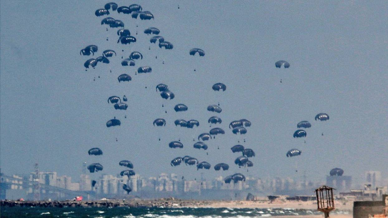 airdropped humanitarian aid parcels float down on parachutes to the beach in Gaza