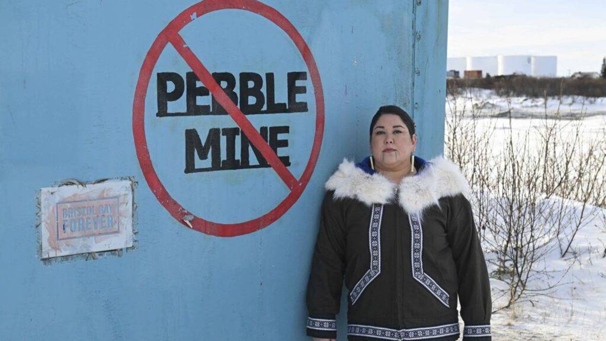 Alannah Acaq Hurley next to No Pebble Mine graffiti.
