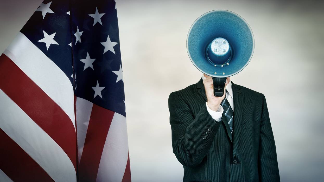 American flad and a person in a business suit yelling into microphone