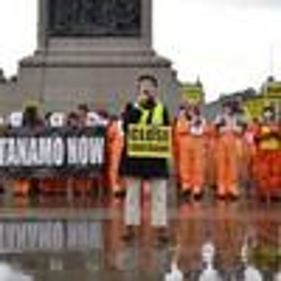 Amnesty International activists dressed in orange jumpsuits and hoods, representing the 39 men still held at Guantanamo