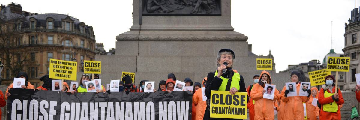 Amnesty International activists dressed in orange jumpsuits and hoods, representing the 39 men still held at Guantanamo