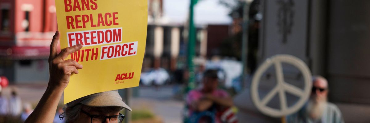 An abortion rights activist holds a placard saying, "Abortion bans replace freedom with force"
