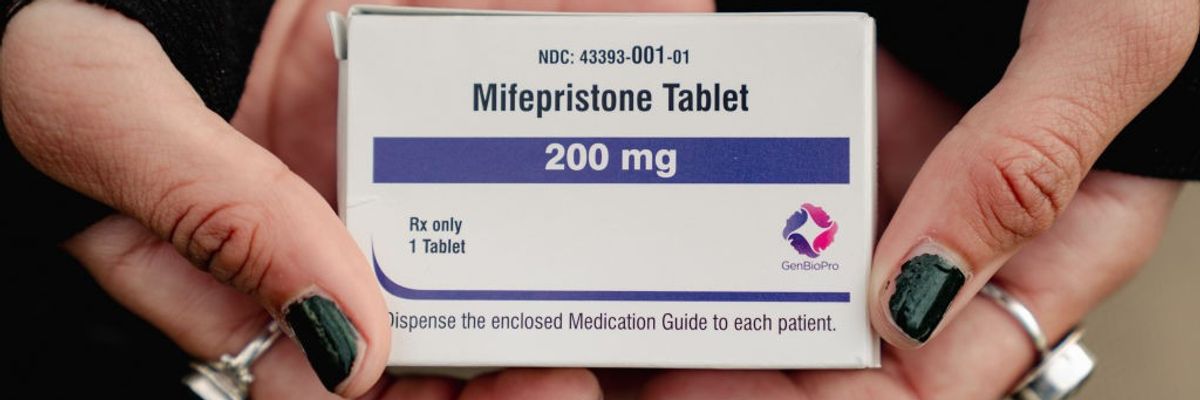 An abortion rights advocate holds a box of mifepristone outside the U.S. Supreme Court