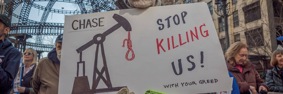 An activist holds a sign in New York City on March 21, 2023 during a national day of action to pressure major banks to stop financing the expansion of the fossil fuel industry.