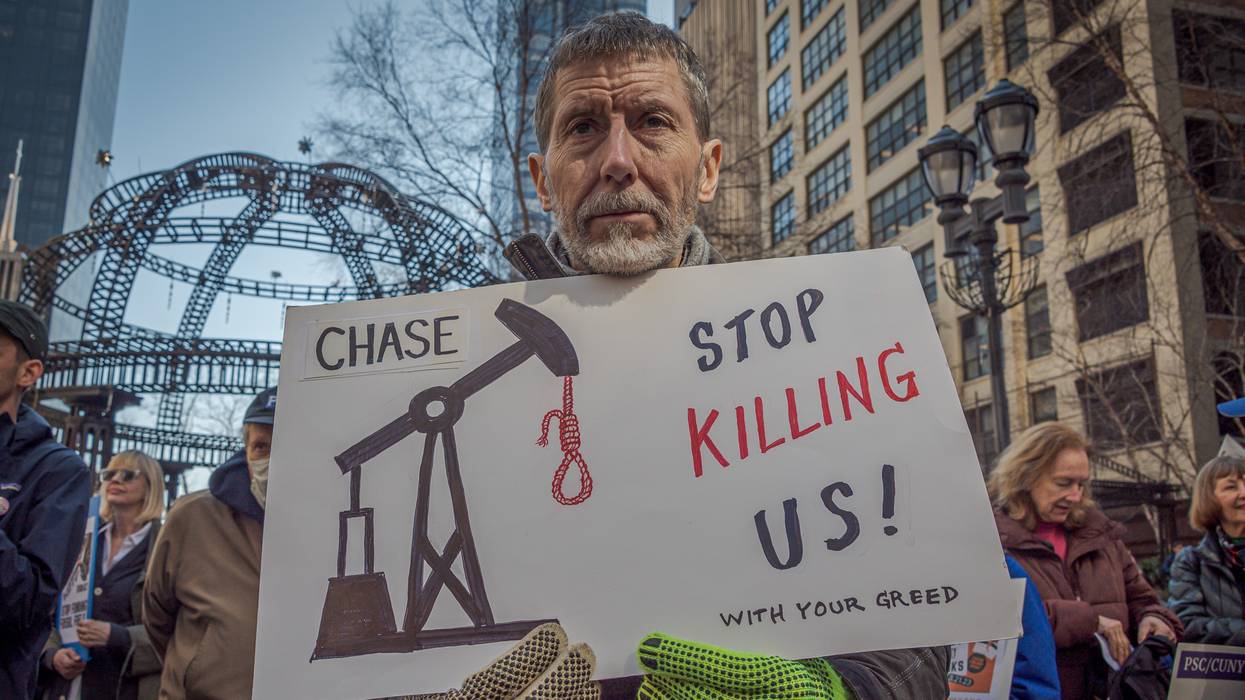 An activist holds a sign in New York City on March 21, 2023 during a national day of action to pressure major banks to stop financing the expansion of the fossil fuel industry.