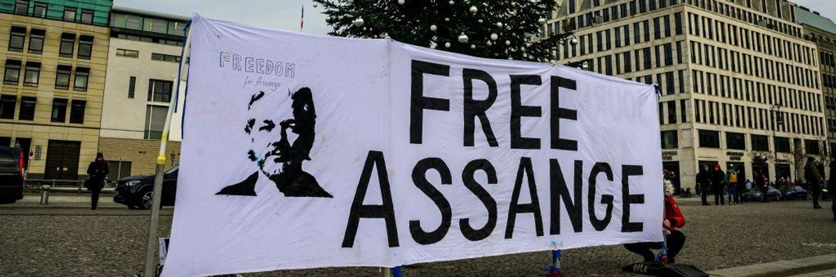 An activist puts up a banner reading "Free Assange" in front of the US embassy in Germany