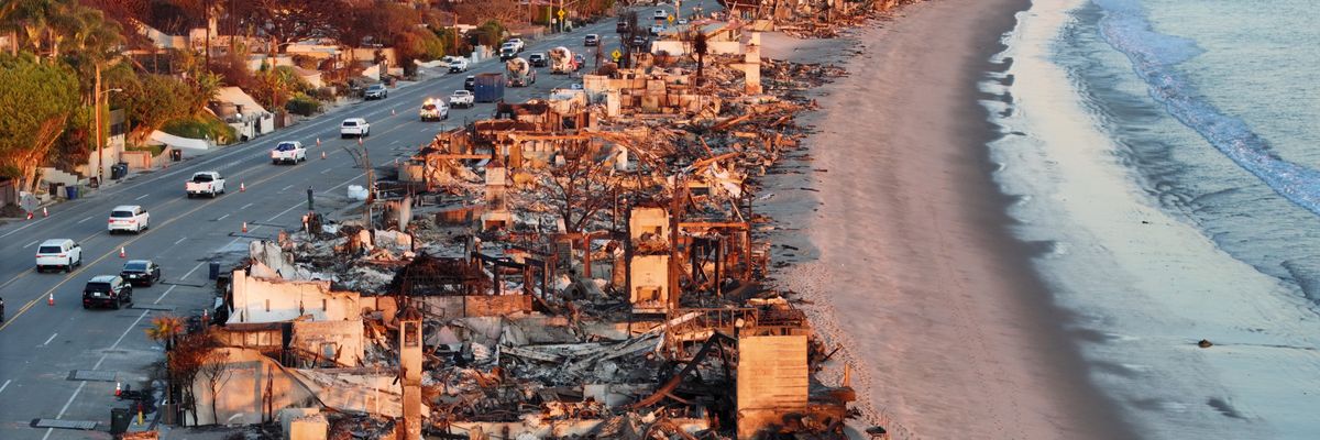 An aerial view of repair vehicles at sunset passing near beachfront homes that burned in the Palisades Fire on January 15, 2025 in Malibu, California.