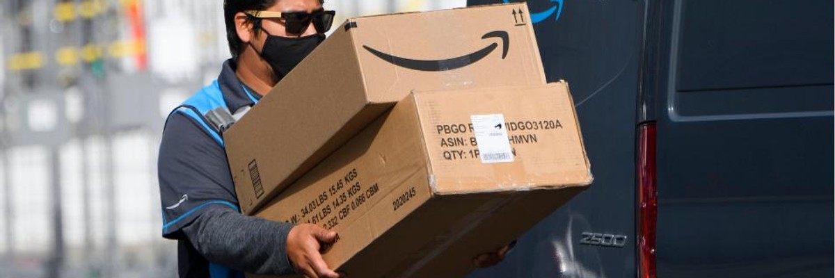 An Amazon delivery driver carries boxes