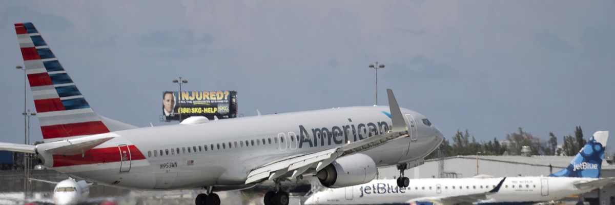An American Airlines plane lands on a runway near a parked JetBlue plane at Florida's Fort Lauderdale-Hollywood International Airport on July 16, 2020. 