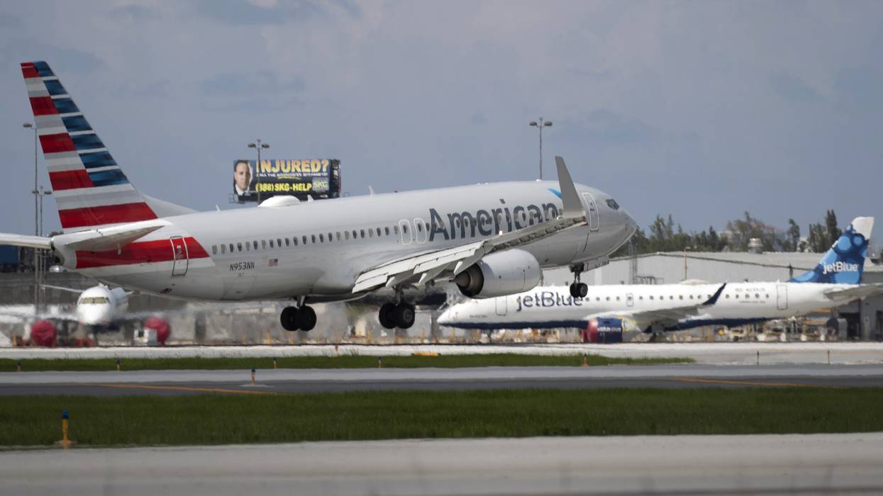 An American Airlines plane lands on a runway near a parked JetBlue plane at Florida's Fort Lauderdale-Hollywood International Airport on July 16, 2020.