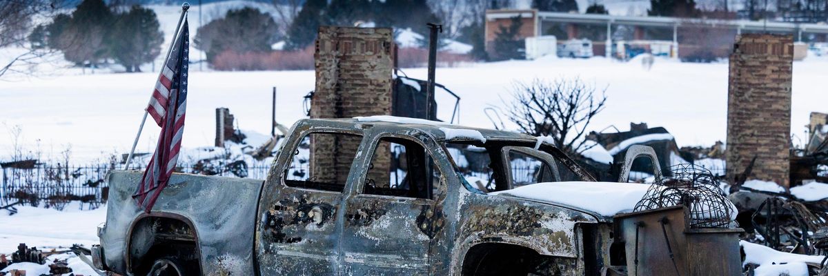 An American flag is shown afixed to a burned truck in a neighborhood decimated by the Marshall Fire on January 2, 2022 in Louisville, Colorado