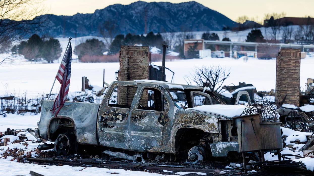 An American flag is shown afixed to a burned truck in a neighborhood decimated by the Marshall Fire on January 2, 2022 in Louisville, Colorado