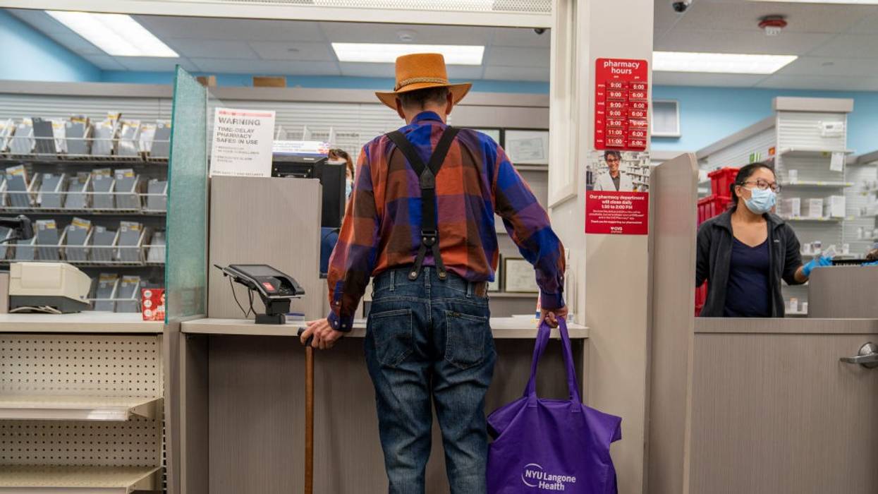 An elderly man waits for his prescription to be filled