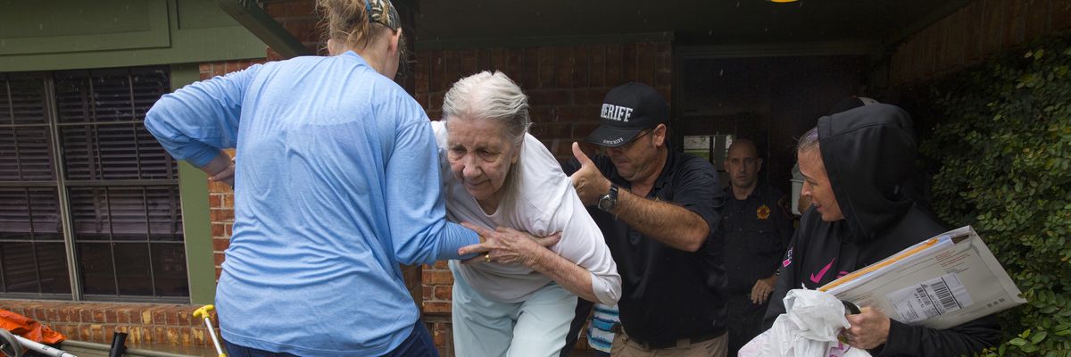 An elderly woman is evacuated from her home amid flooding caused by heavy rain during Hurricane Harvey