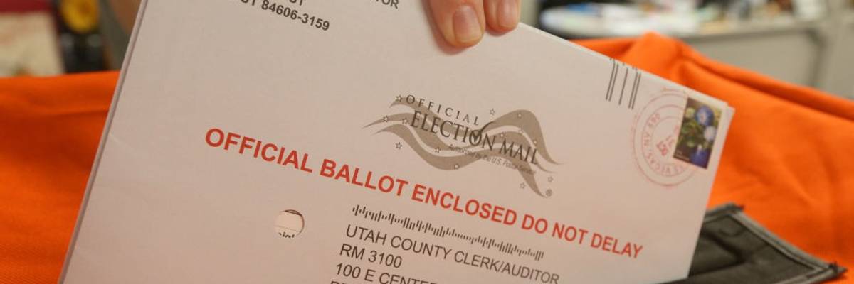 An election worker handles a mail-in ballot