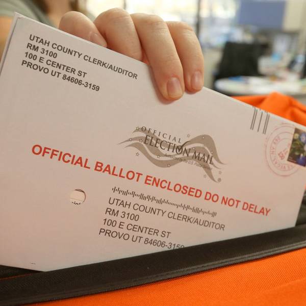 An election worker handles a mail-in ballot