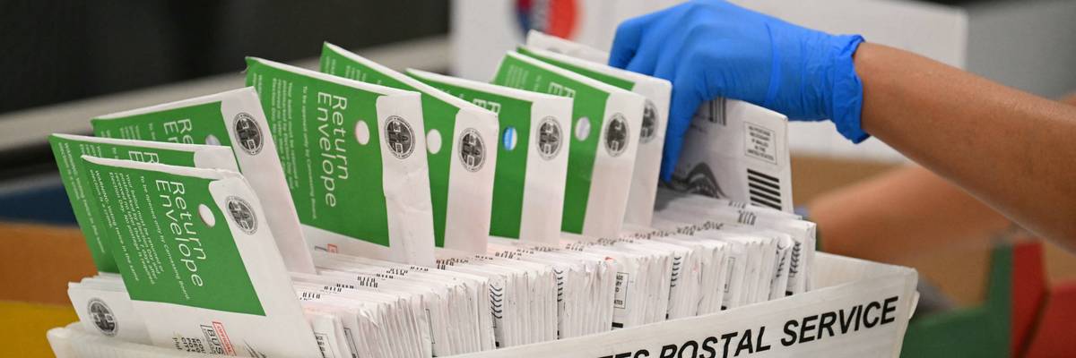An election worker processes mail-in ballots.