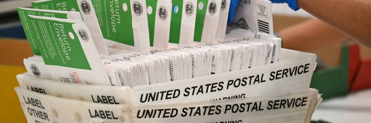 An election worker processes mail-in ballots