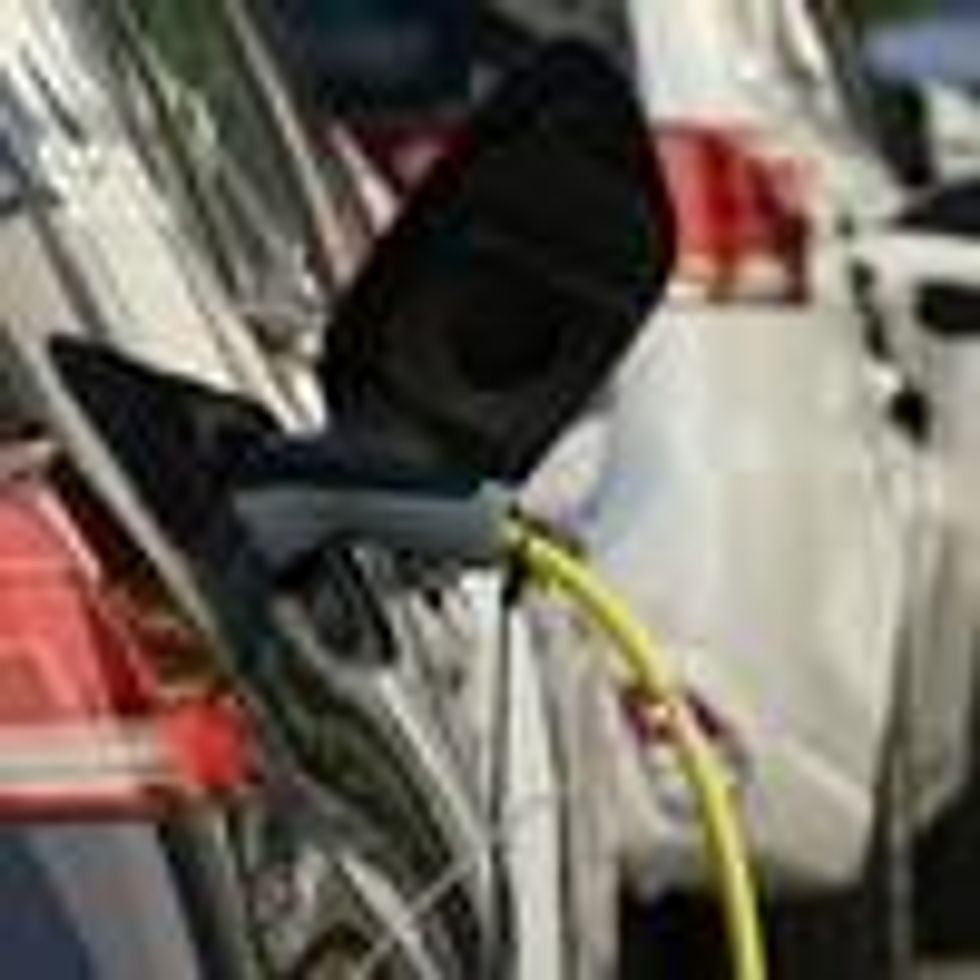 An electric car and a plug-in hybrid car charge at a public charging station on October 12, 2019 in Berlin.