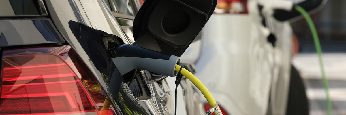 An electric car and a plug-in hybrid car charge at a public charging station on October 12, 2019 in Berlin.