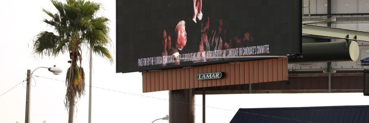 An electronic billboard advertisement paid for by the Florida Democratic Party reading "Never Forget" and showing US President Donald Trump throwing a roll of paper towels is seen along the Florida Turnpike in Kissimmee, Florida, on January 16, 2020