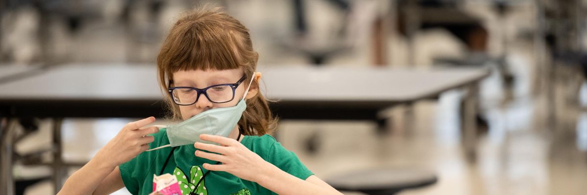 An elementary school student finishes a meal