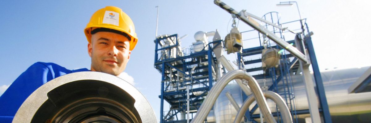 An employee poses with a pipe used to carry liquid CO2