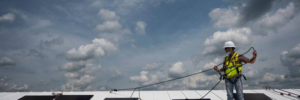 An employee with Ipsun Solar installs solar panels on the roof of the Peace Lutheran Church in Alexandria, Virginia on May 17, 2021.