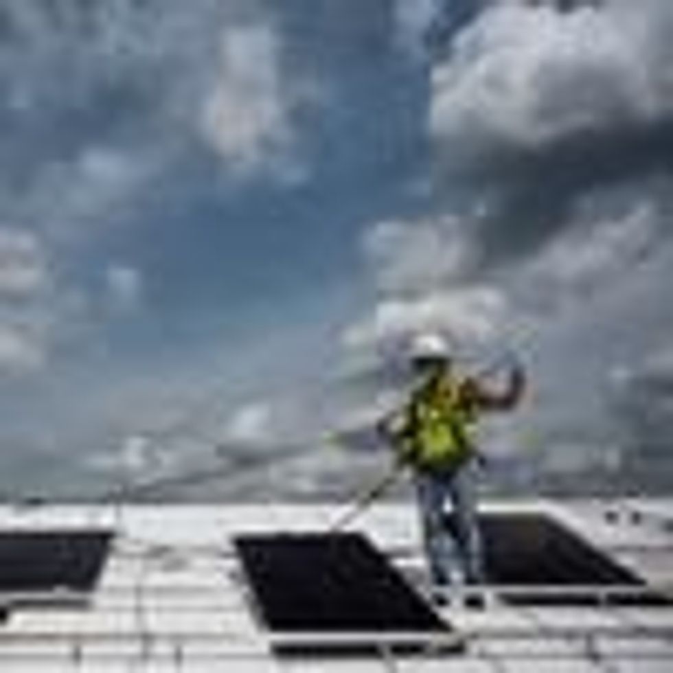 An employee with Ipsun Solar installs solar panels on the roof of the Peace Lutheran Church in Alexandria, Virginia on May 17, 2021.