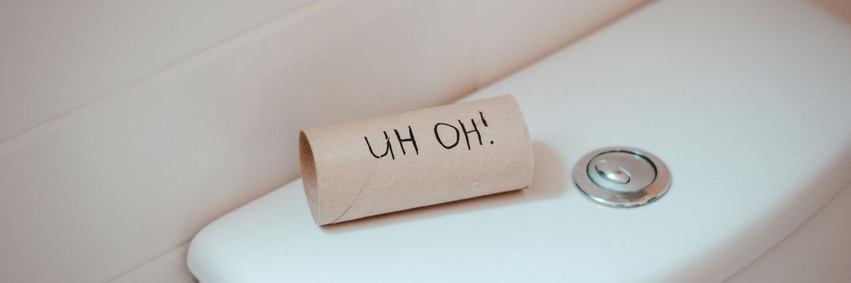 An empty roll of toilet paper on top of a toilet says, "Uh oh!"