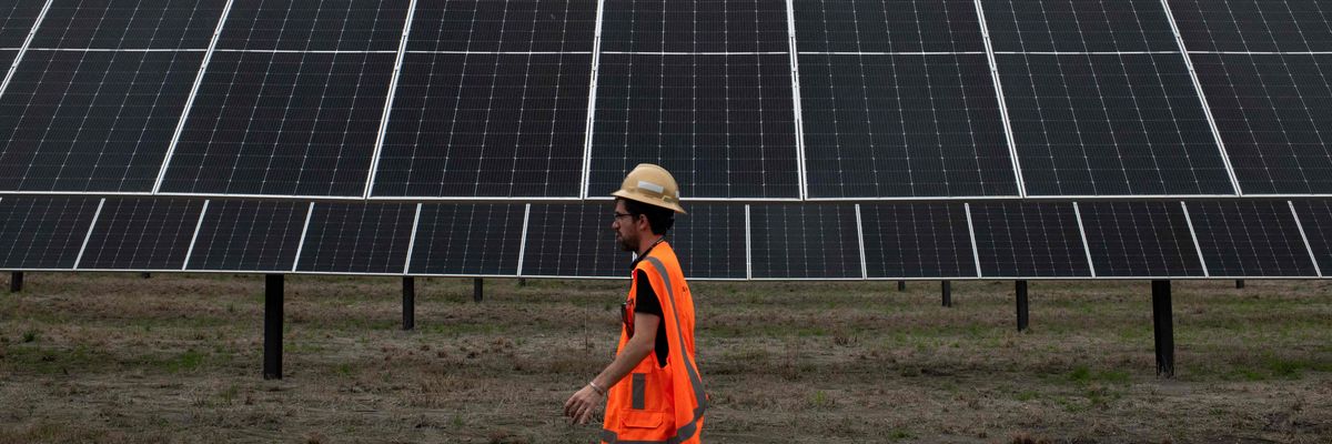 An ENGIE employee walks past solar panels