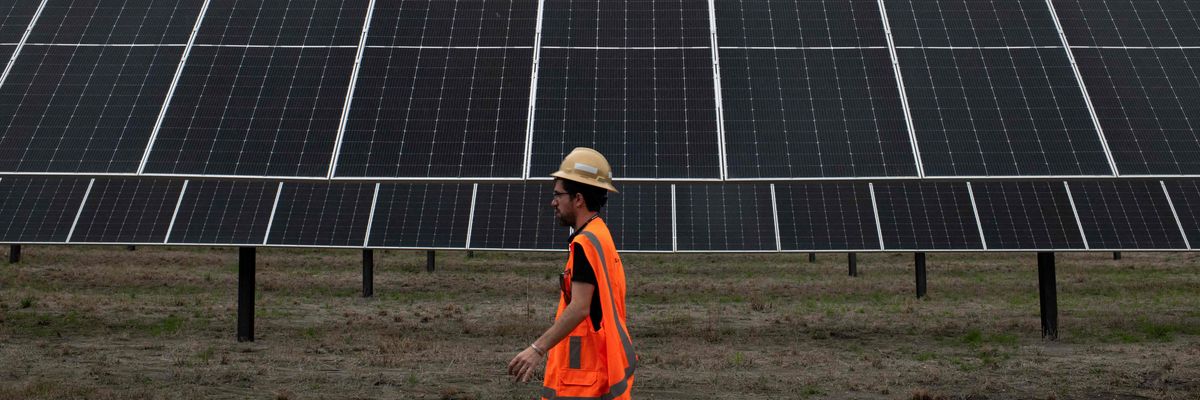 An ENGIE employee walks past solar panels