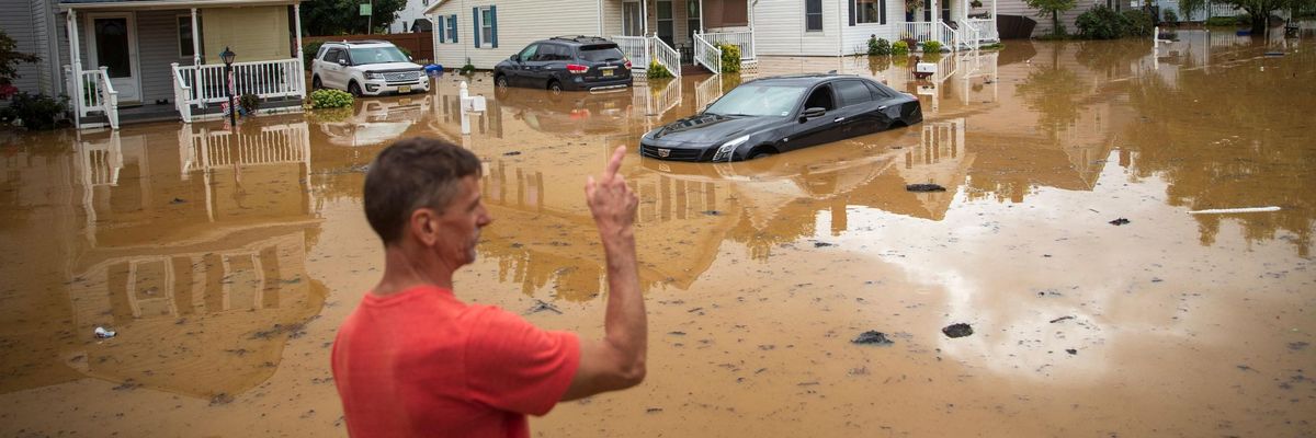 An evacuated resident points in the direction of his home following a flash flood, which came as Tropical Storm Henri made landfall, in Helmetta, New Jersey on August 22, 2021.