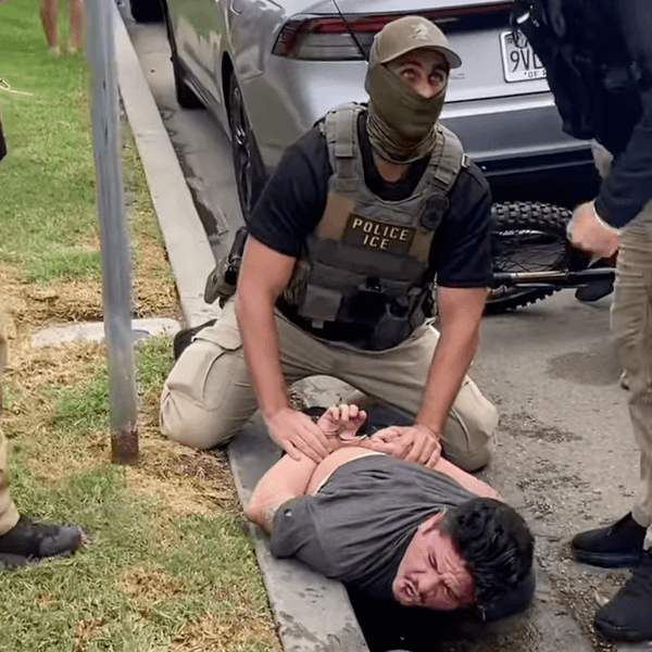 An ICE agent pins Ricardo Gonzalez to the ground