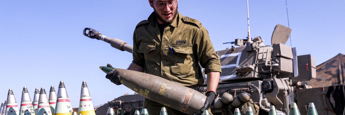 An IDF soldier readies a 155mm artillery shell for loading in a howitzer.