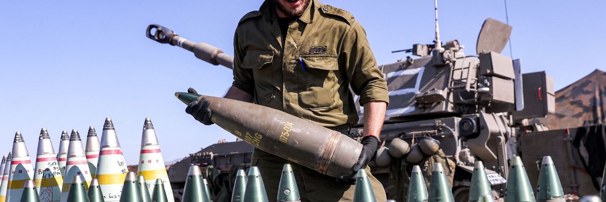 An IDF soldier readies a 155mm artillery shell for loading in a howitzer.
